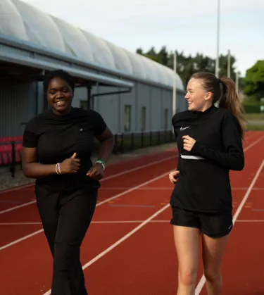 two girls running on track 