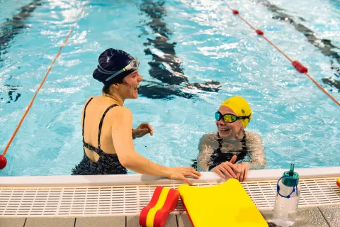 adults laughing at swimming lessons in the pool